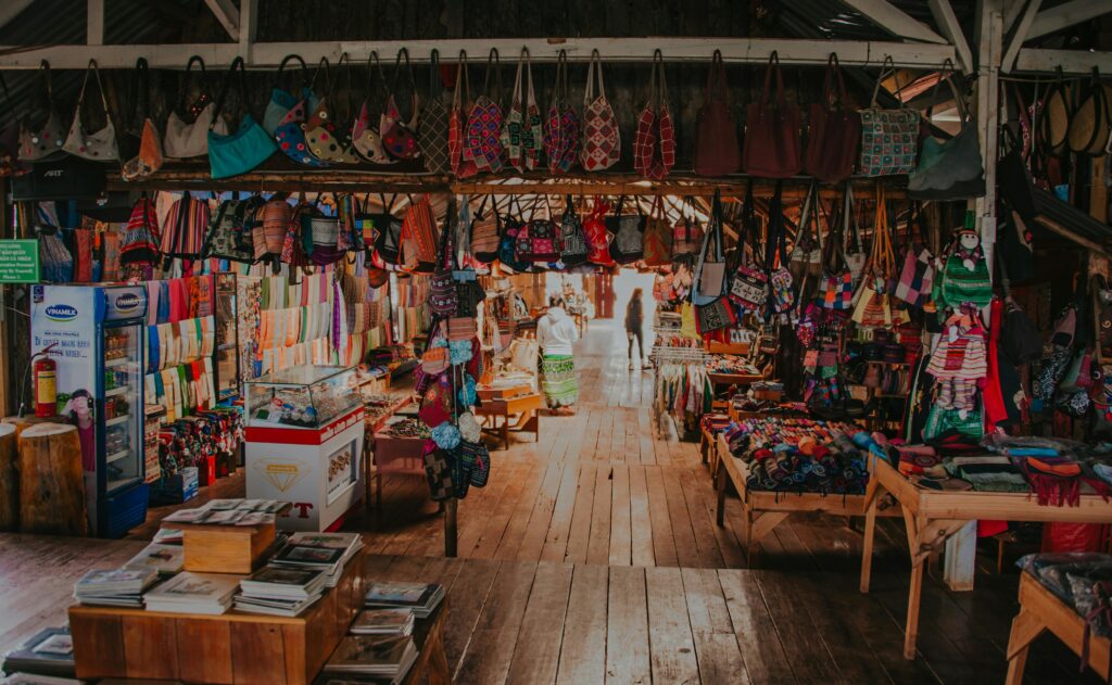 pexels photo 1087727 1087727 A colorful array of handcrafted bags and textiles in a lively indoor market setting.