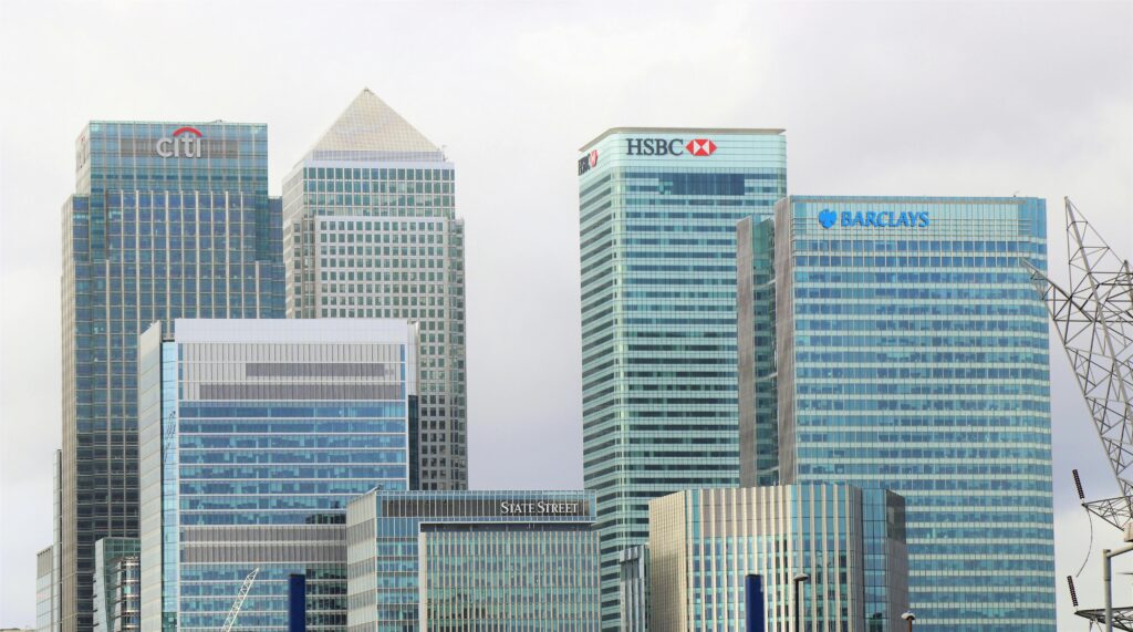 Banking 101: Checking vs. Savings vs. That Random Account Your Parents Opened for You Modern skyline of Canary Wharf featuring iconic bank skyscrapers like HSBC and Barclays.