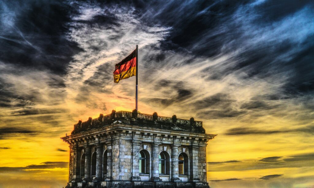 Germany: Cash is King Vibrant sunset over a historic Berlin monument with the German flag waving.